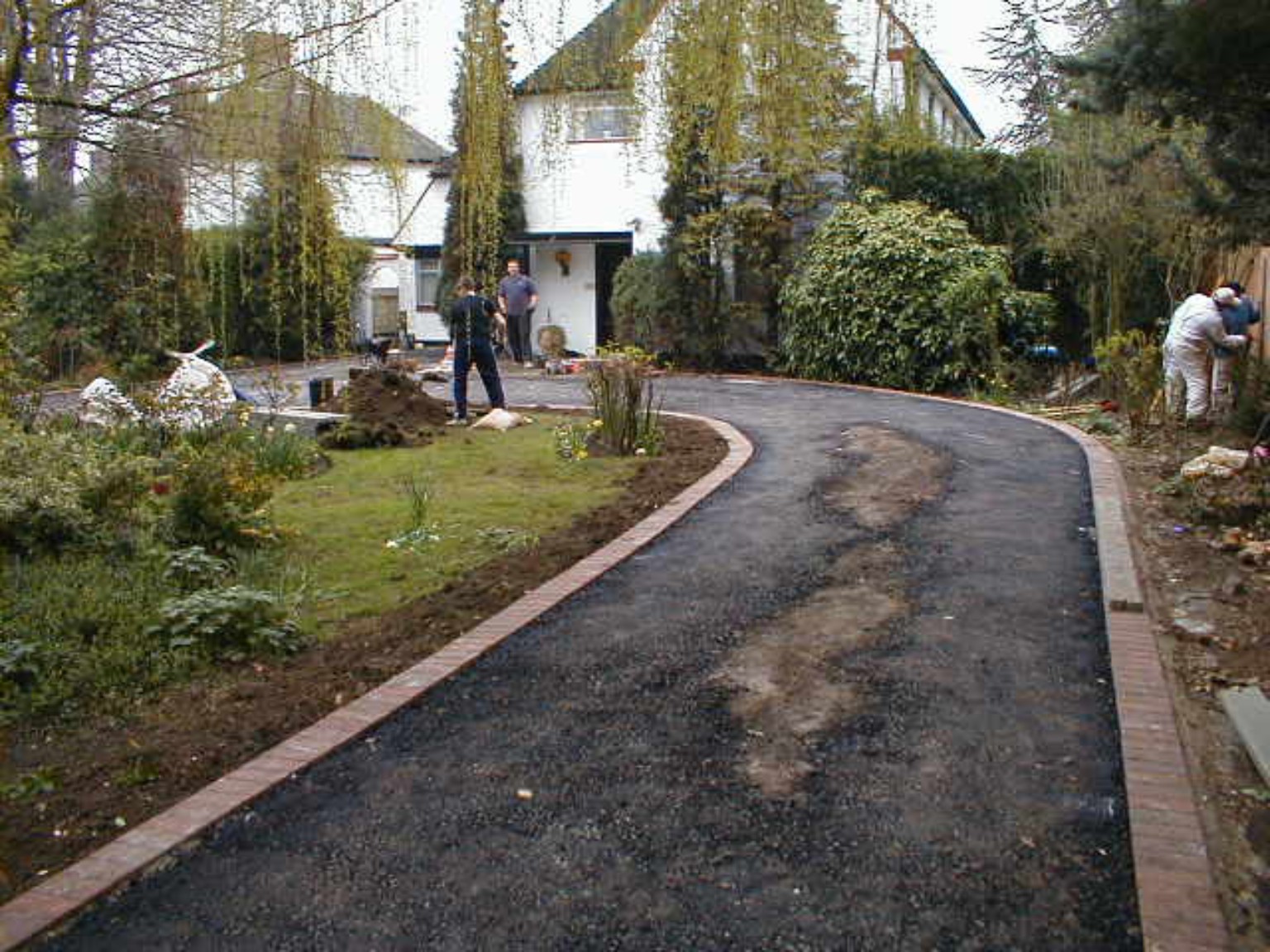 Large curved driveway in Crieff, Perthshire during resurfacing, with block-paved borders around the garden