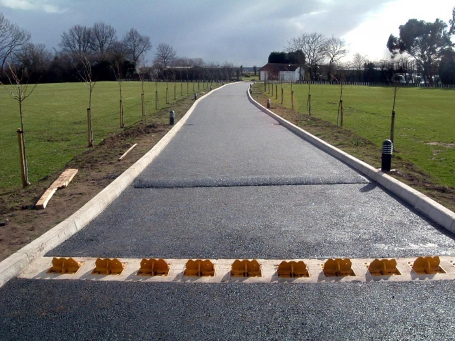 Completed two-layer tarmac private road in Dumbarton, Scotland, running between kerbs and landscaped verges
