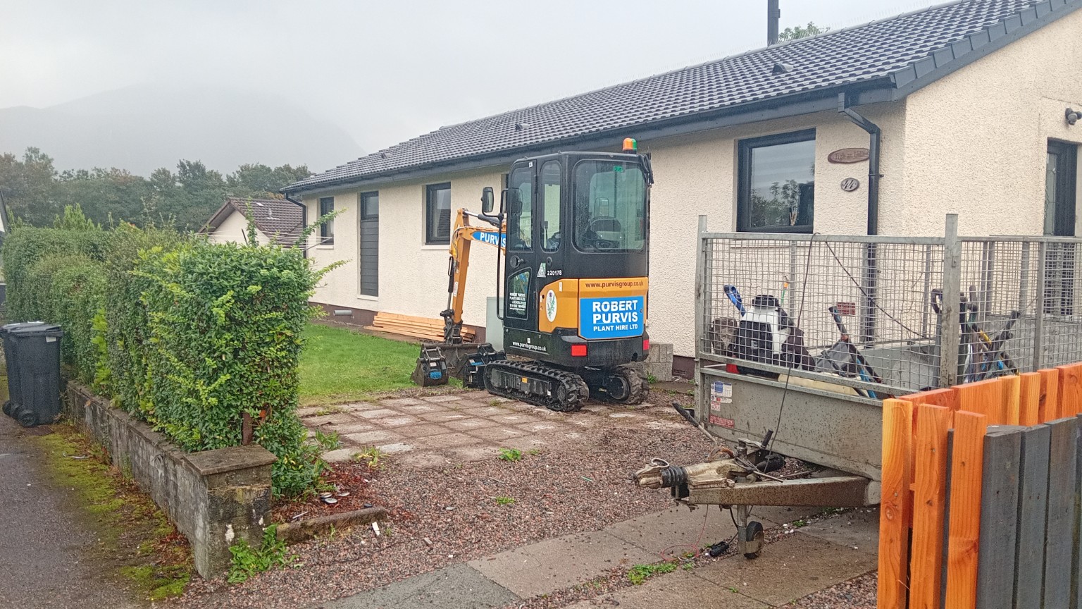 Side view of the original Fort William driveway and front garden, with an excavator on site