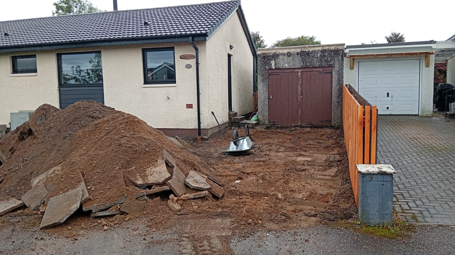 Fort William driveway during excavation, with lifted concrete slabs and excavated material