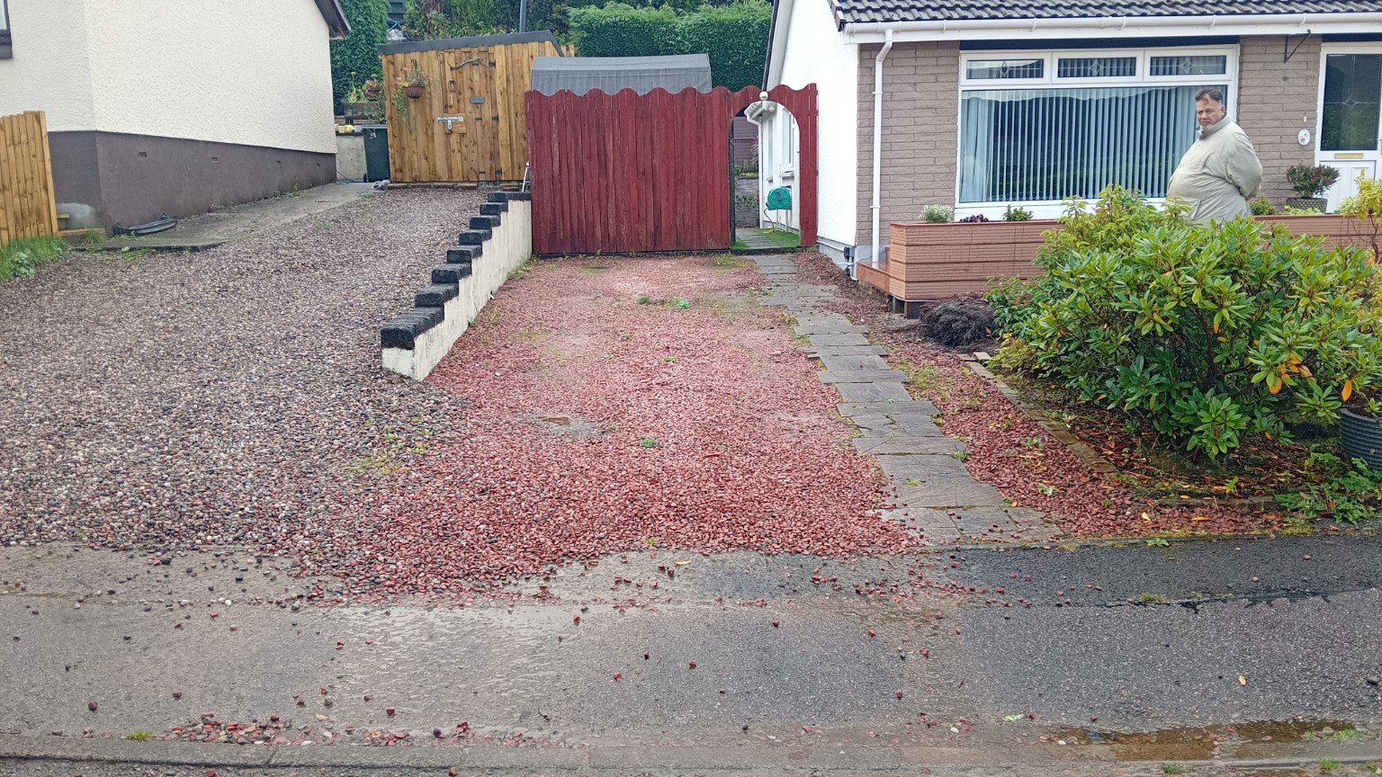 Two neighbouring gravel driveways in Fort William before work, separated by a low wall