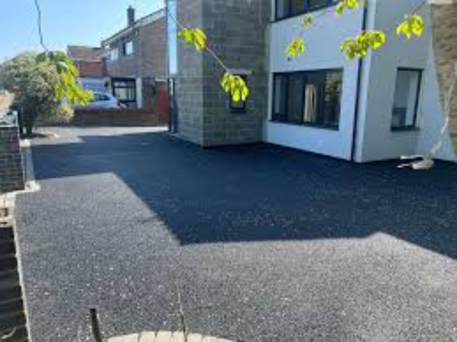 Completed hot tarmac driveway beside a stone and white house in Prestwick, Ayrshire
