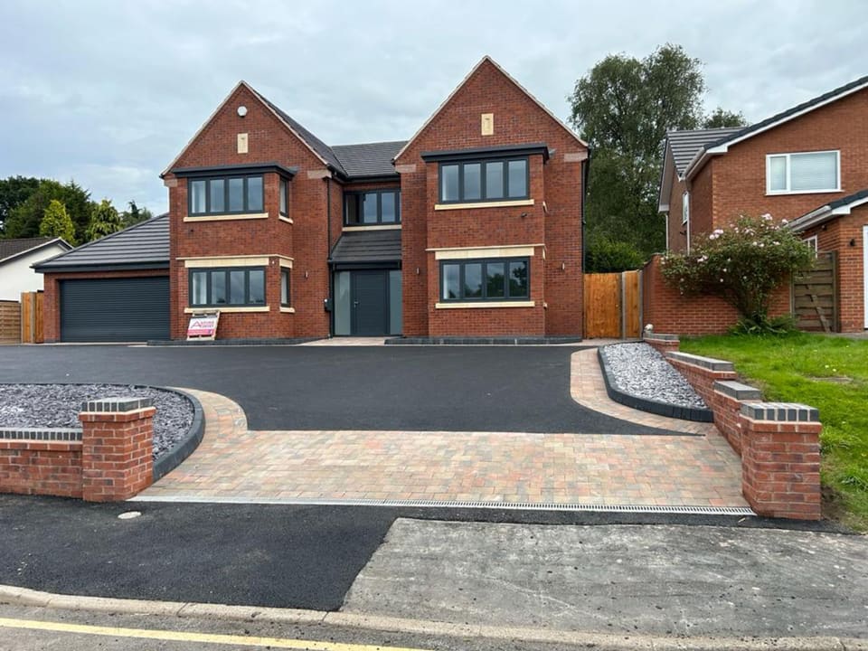 Completed tarmac driveway with block-paved borders and a broad entrance