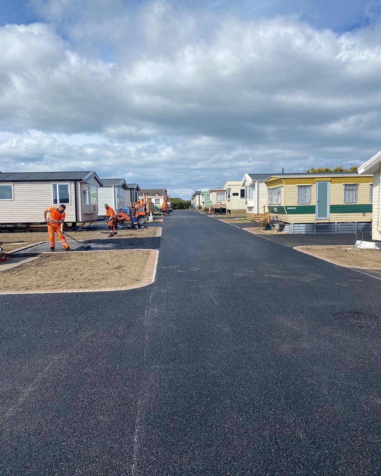 Team working beside freshly machine-laid tarmac at a caravan park in the Scottish Highlands between Perth and Inverness
