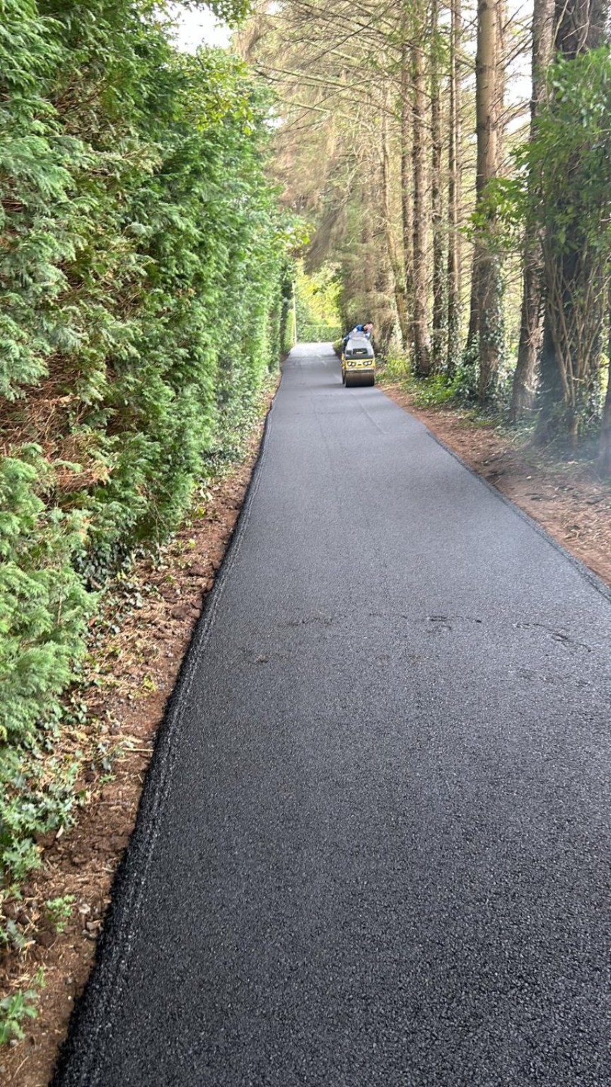Freshly surfaced tree-lined access road to a large potato farm in Tayside, Scotland